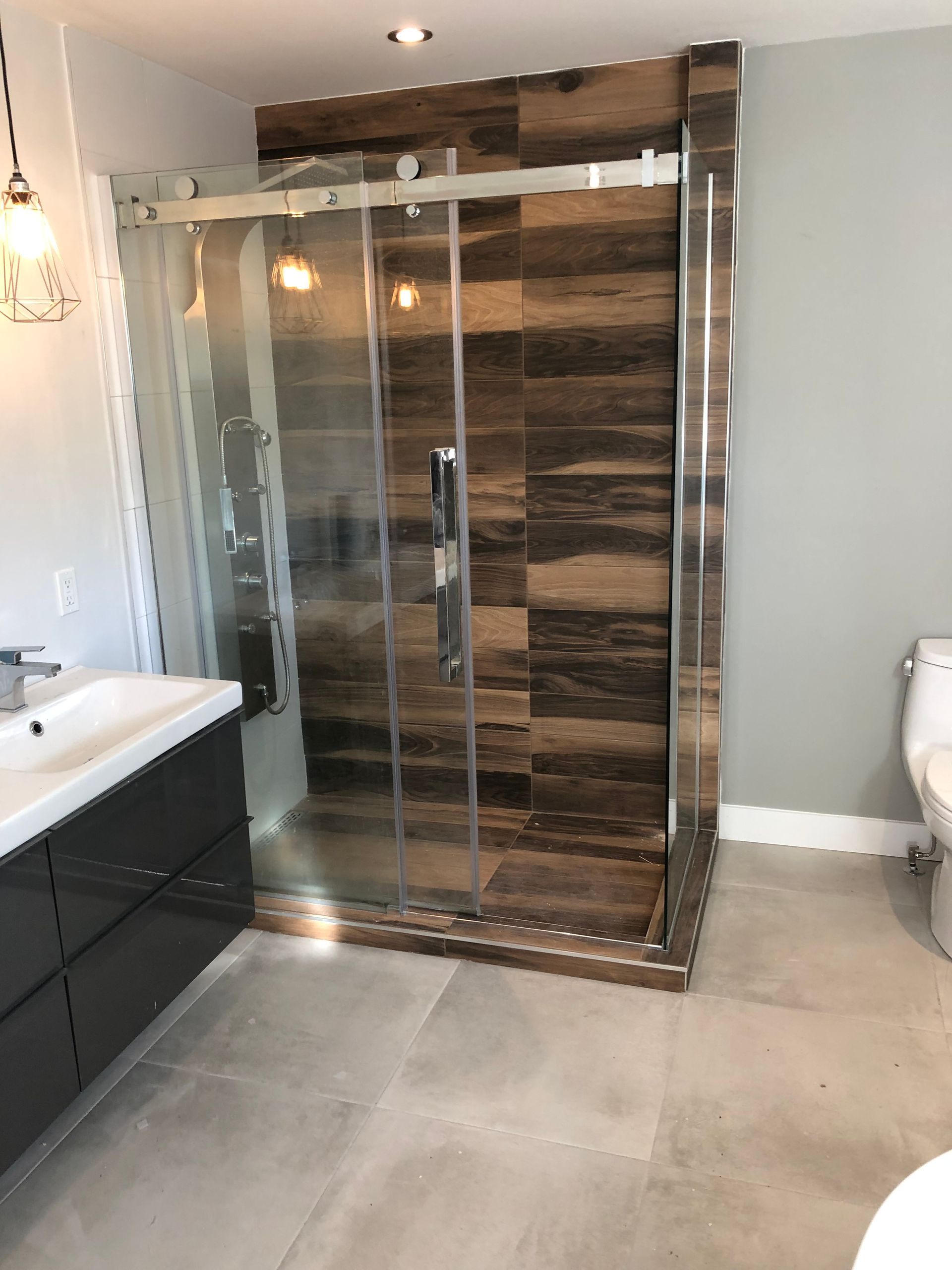 Une salle d'eau avec douche à l'italienne, lavabo et toilettes.