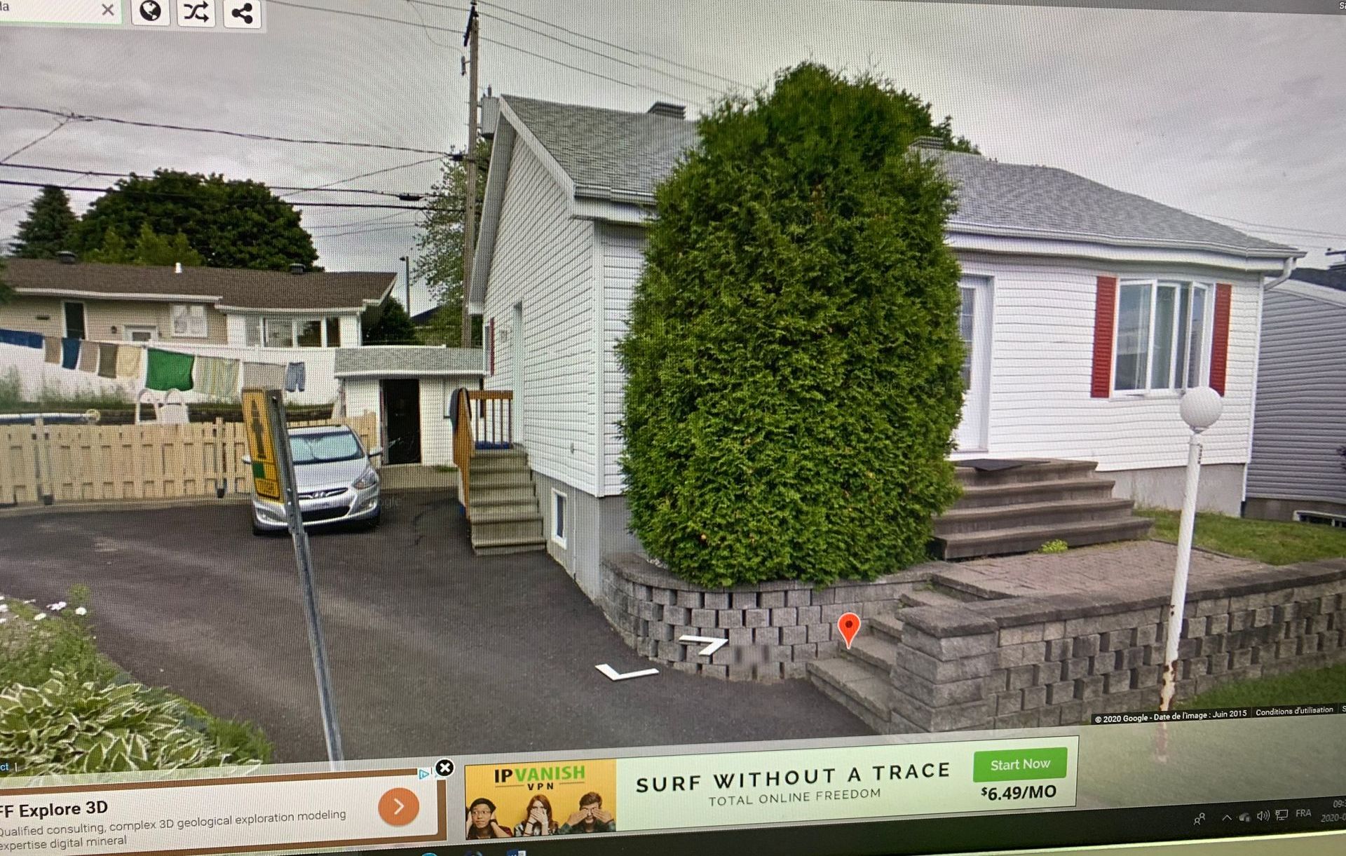 Un écran d'ordinateur montre une maison avec une voiture garée devant elle