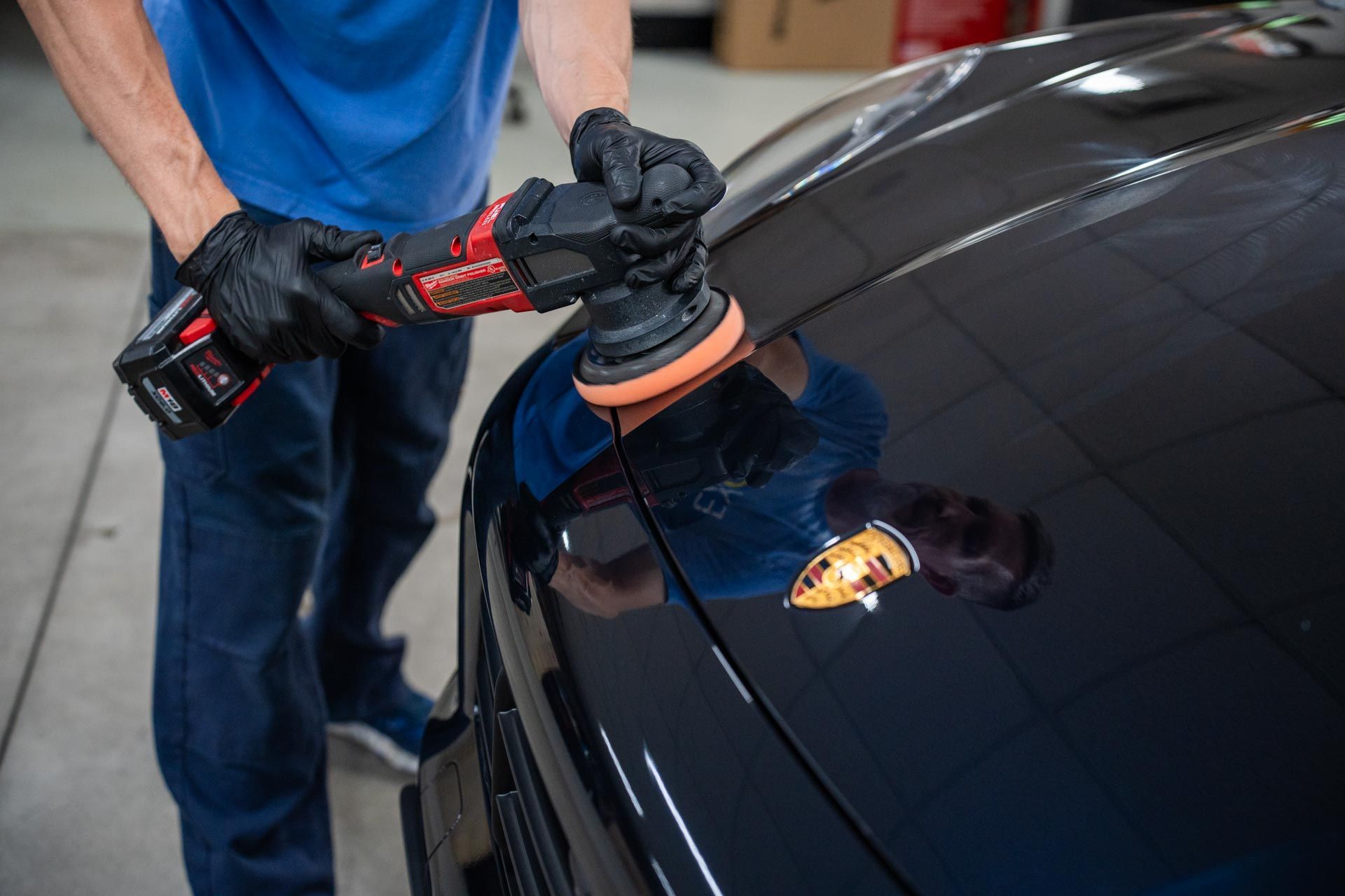 a man is polishing the hood of a black car .