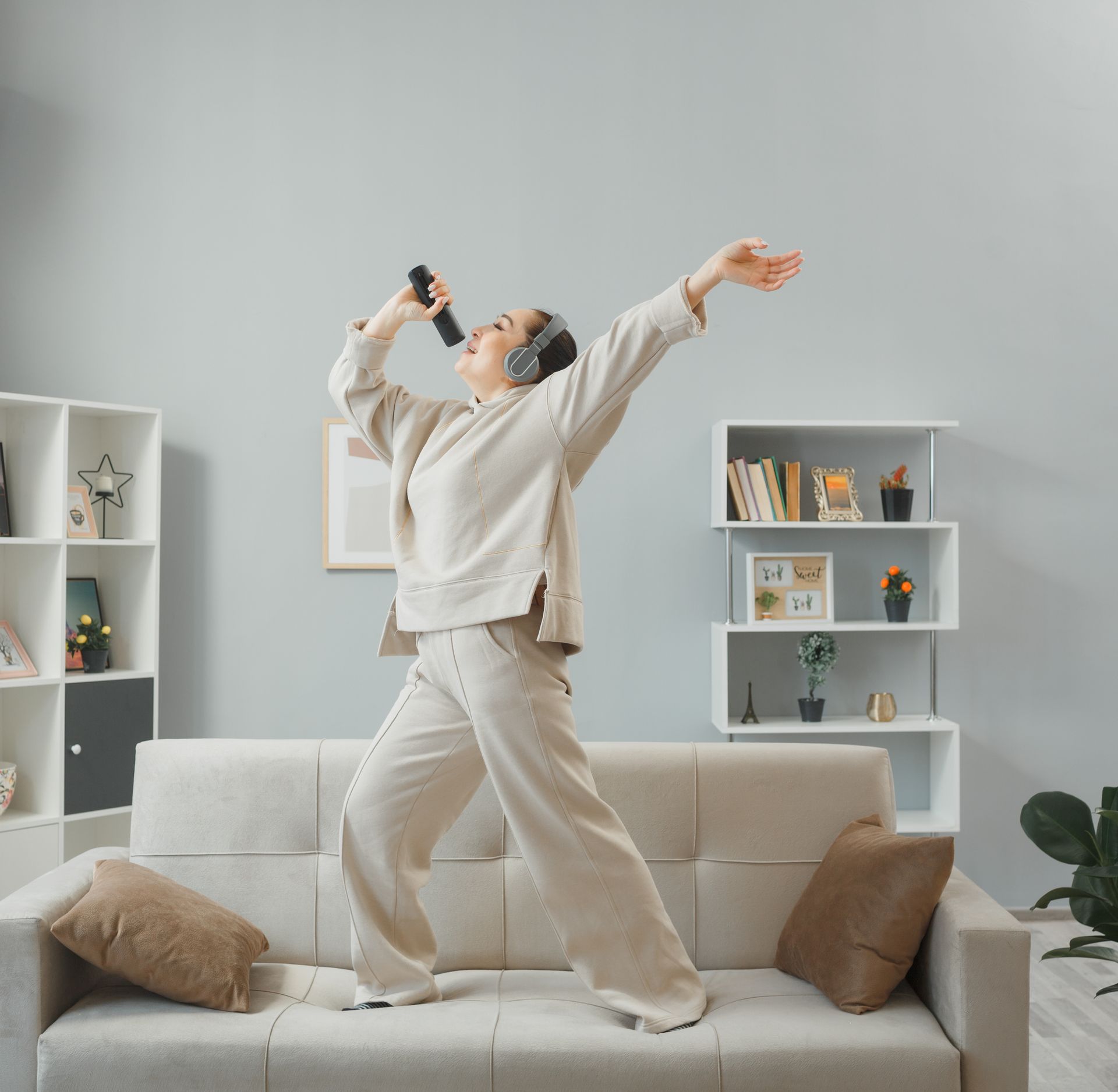 A woman is singing into a microphone in a living room