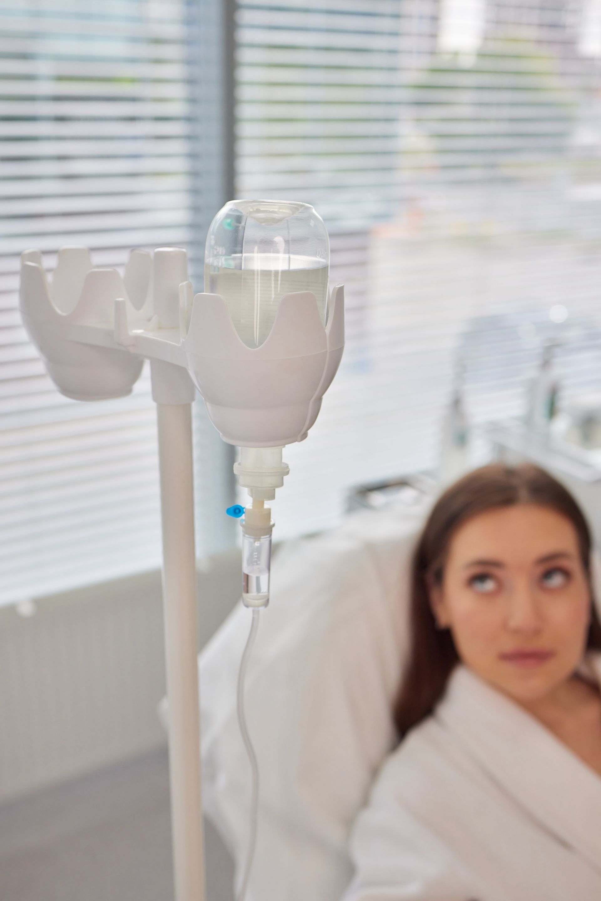 A woman is laying in a hospital bed with an iv in her arm.