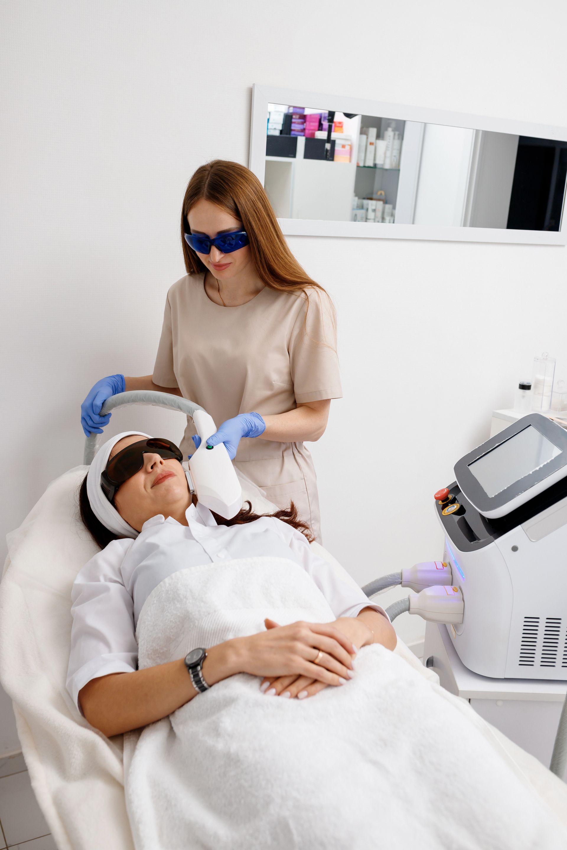 A woman is getting a laser hair removal treatment in a beauty salon.