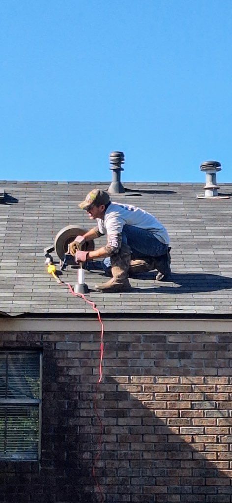 Person wearing black gloves using a wrench to tighten a pipe under a bathroom sink.