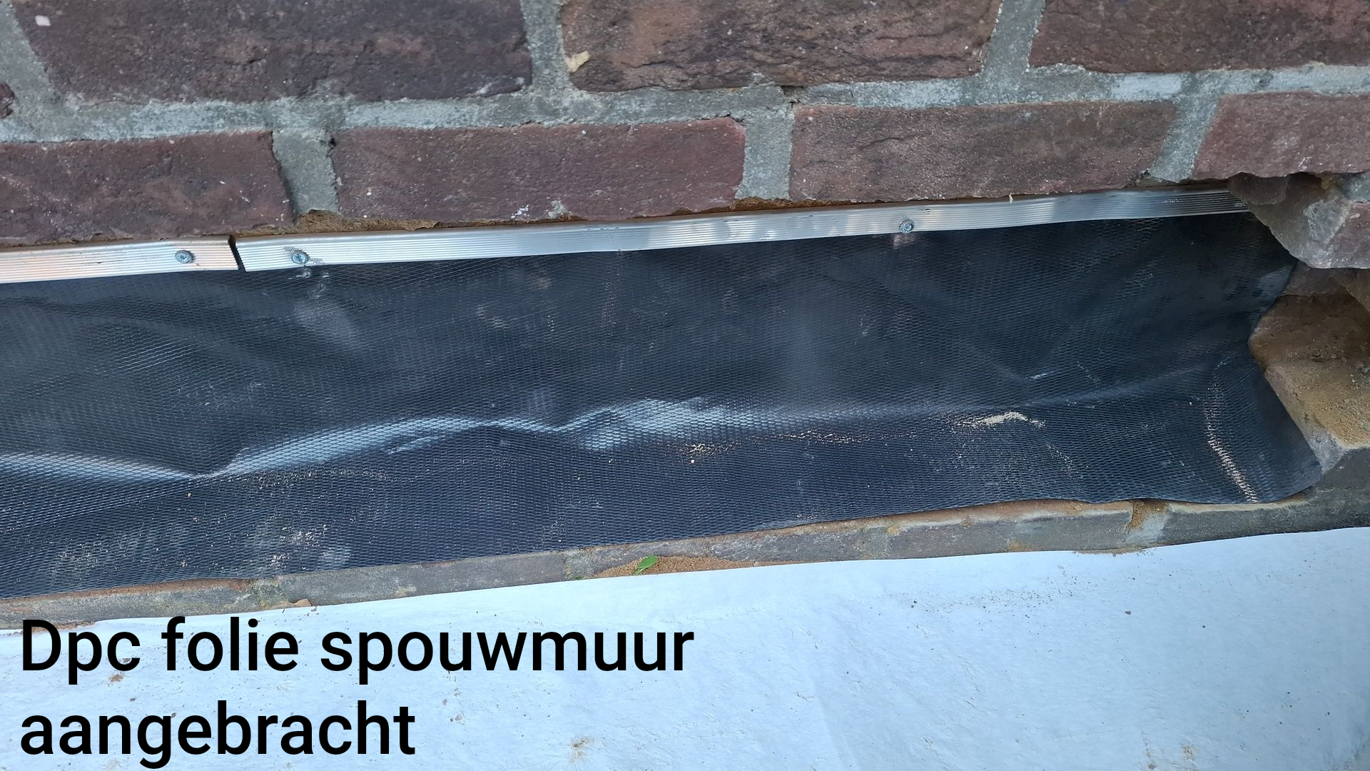 DPC foil installed along base of brick wall, labeled “Dpc folie spouwmuur aangebracht”