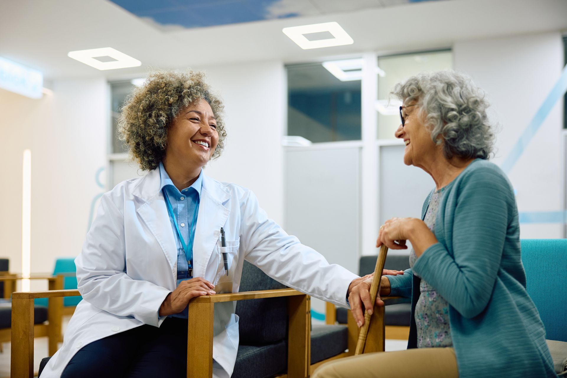 A doctor is talking to an elderly woman in a hospital waiting room.