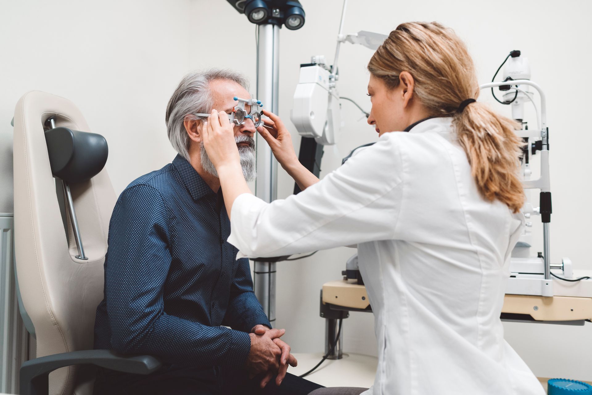 A female doctor is sitting at a desk talking to an older man.