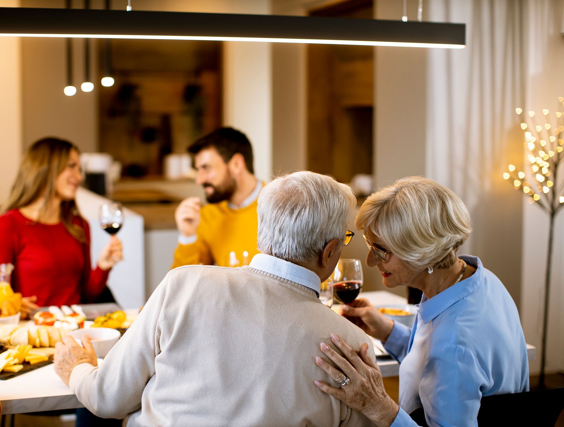 A group of older people are drinking wine together and laughing.