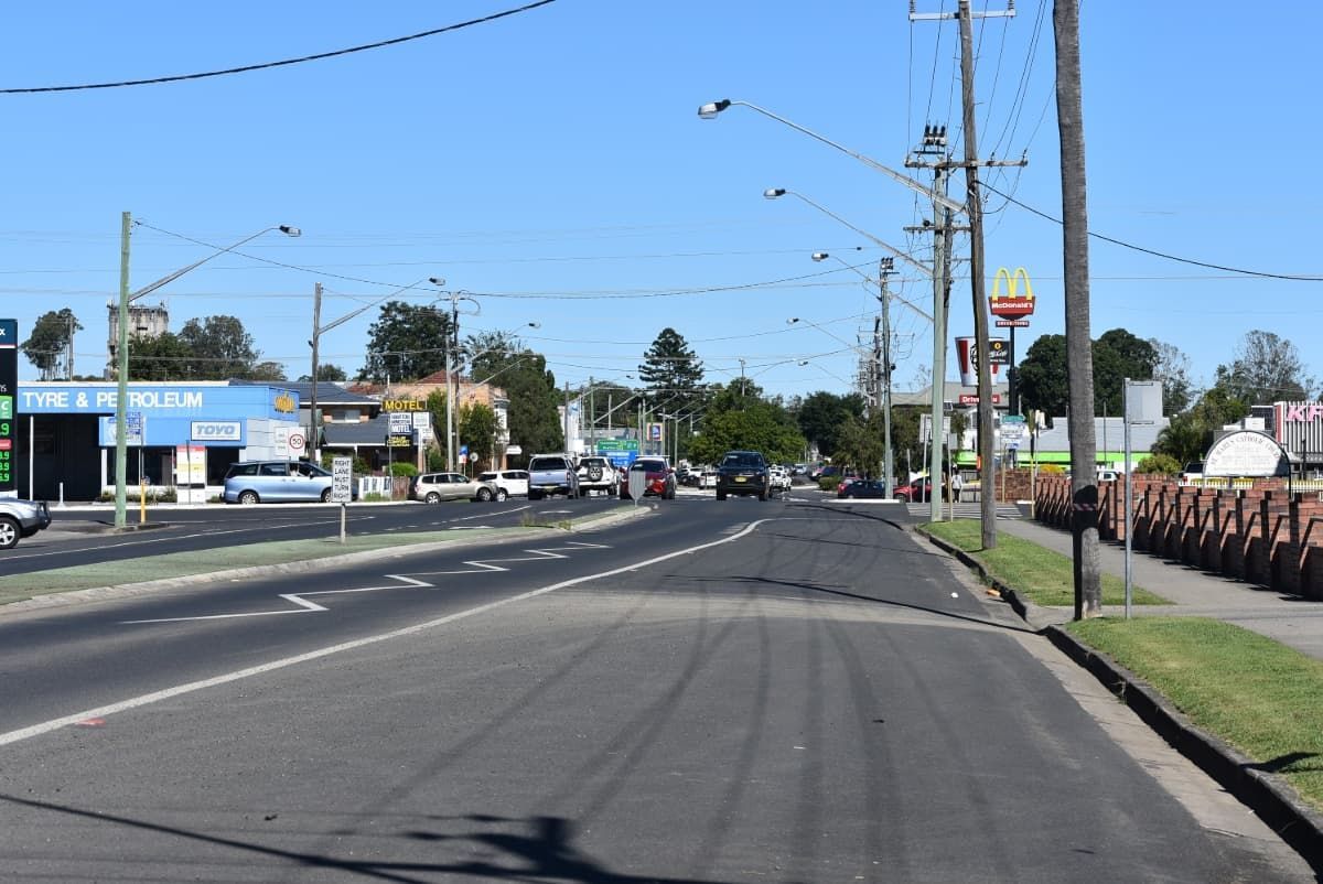 A Car Is Driving Down a Street in A Small Town — Lismore Floor Sanding in Casino, NSW