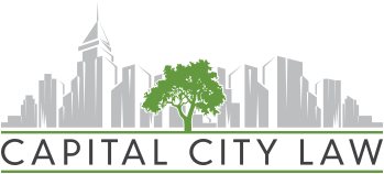 Logo for Capital City Law featuring a tree in front of a city skyline, with text below.