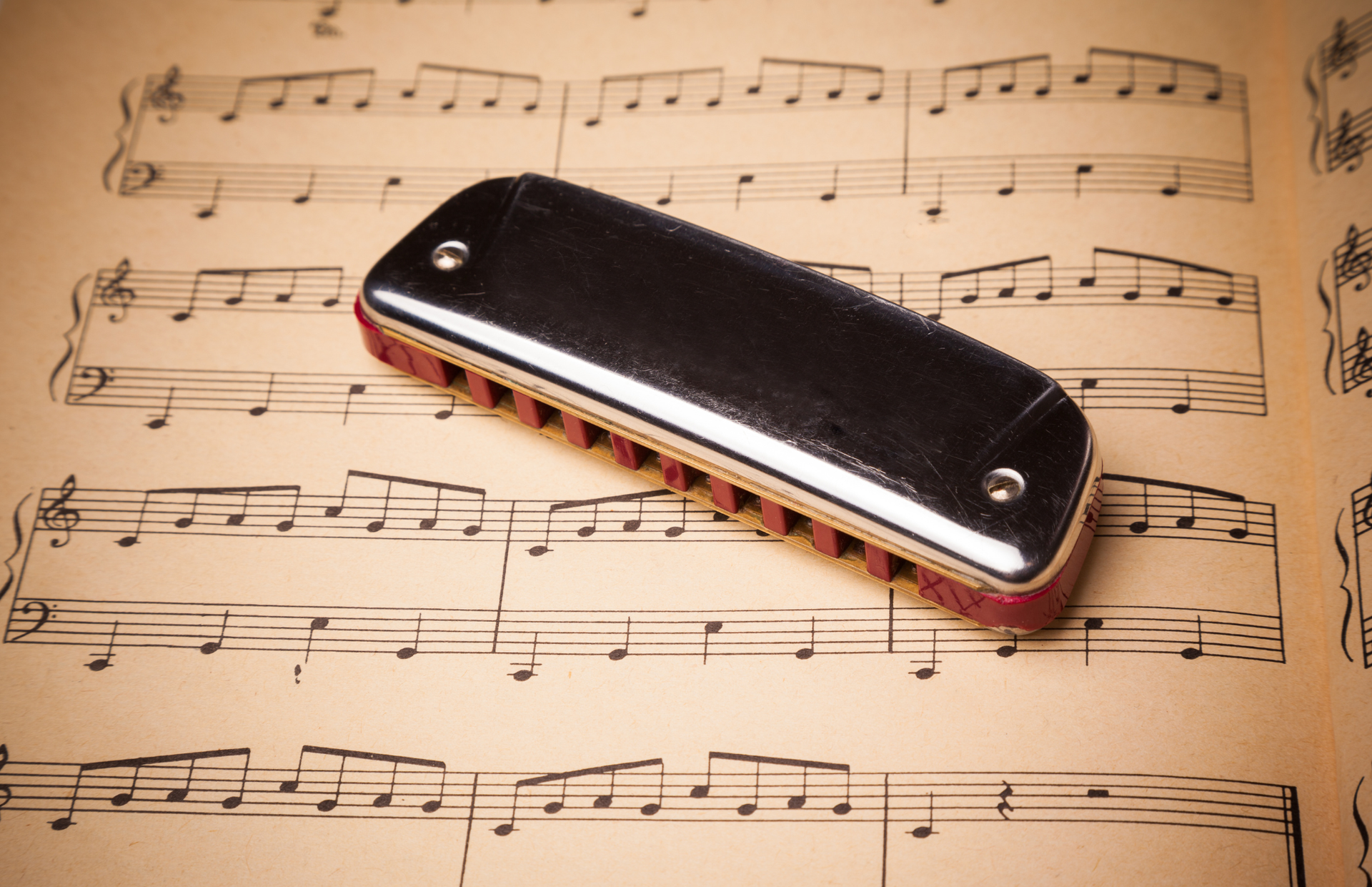 Black harmonica on sheet music pages