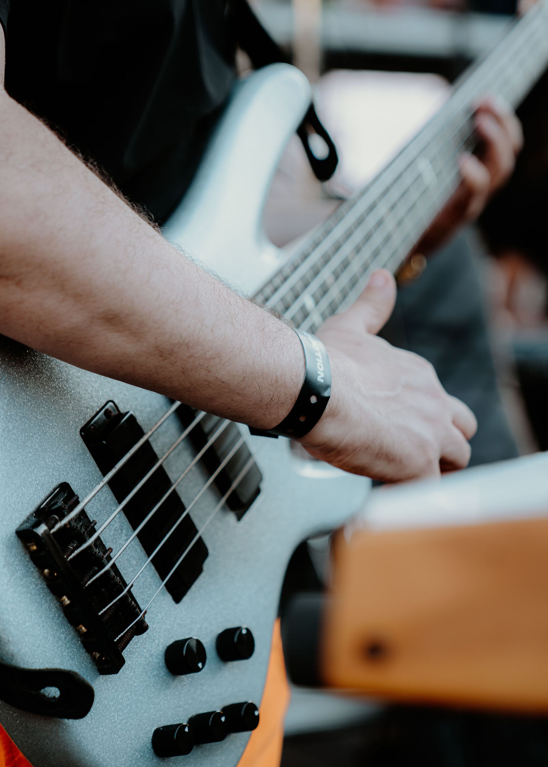 Hands playing an acoustic guitar close-up, with fingers on the fretboard.