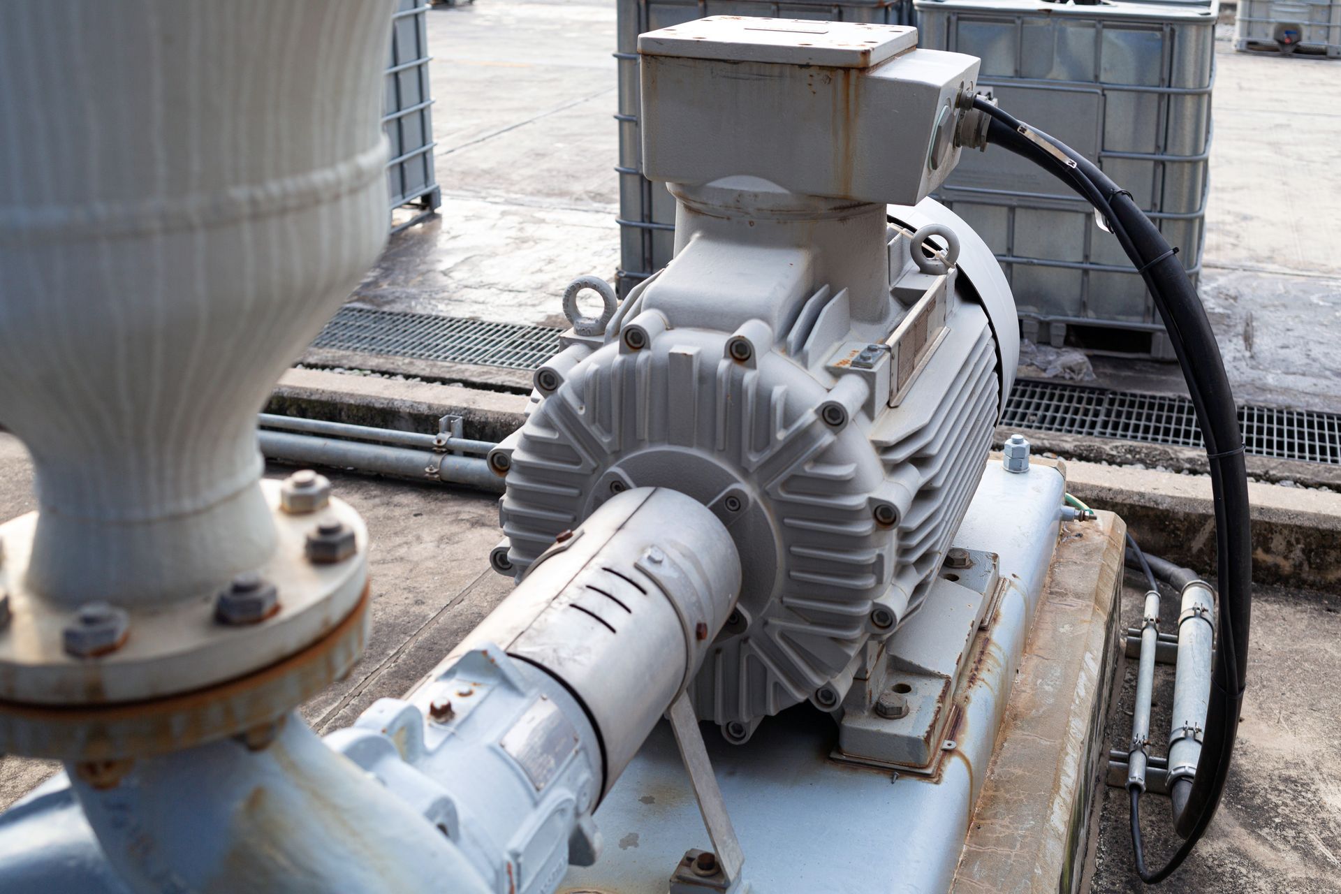 Industrial pump and motor assembly with connected pipes in a factory setting