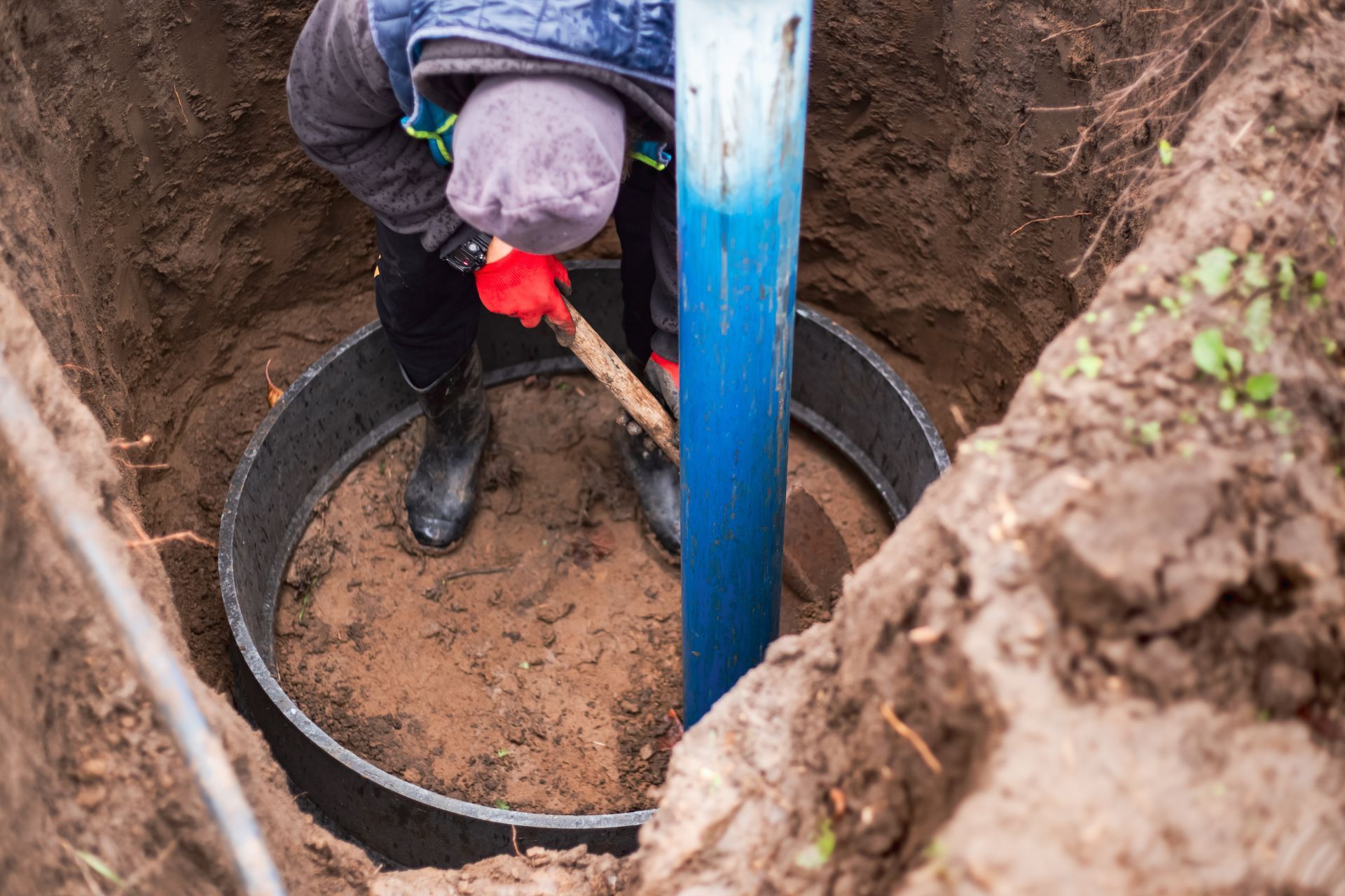 A worker installs a water intake unit in a well.