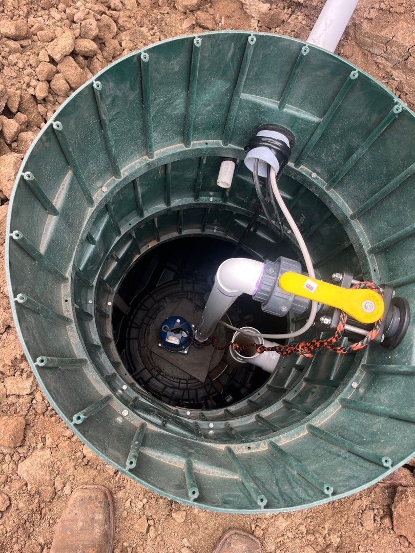 Worker cutting a blue pipe with a pipe cutter during plumbing repair