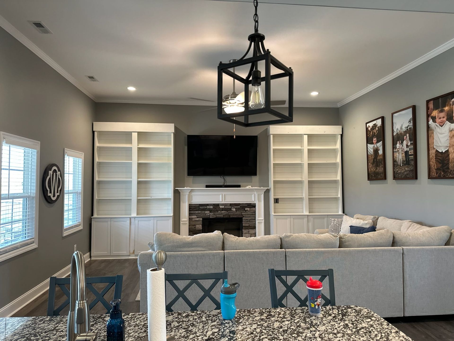 A living room with a couch , fireplace , television and shelves.