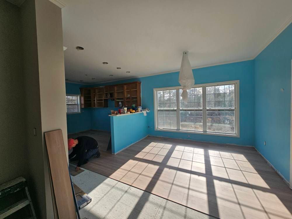 A living room with blue walls and a lot of windows.
