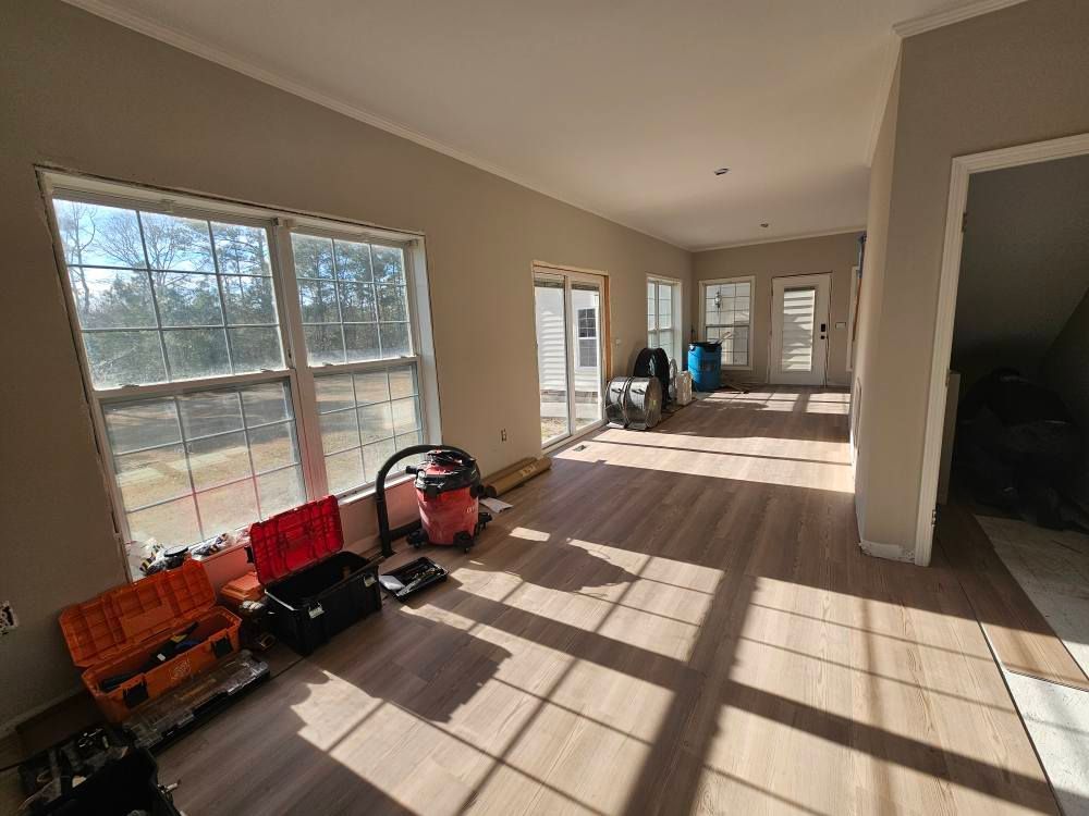 A living room with hardwood floors and lots of windows.