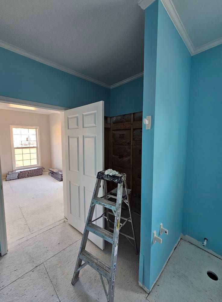 A ladder is sitting in a room with blue walls.