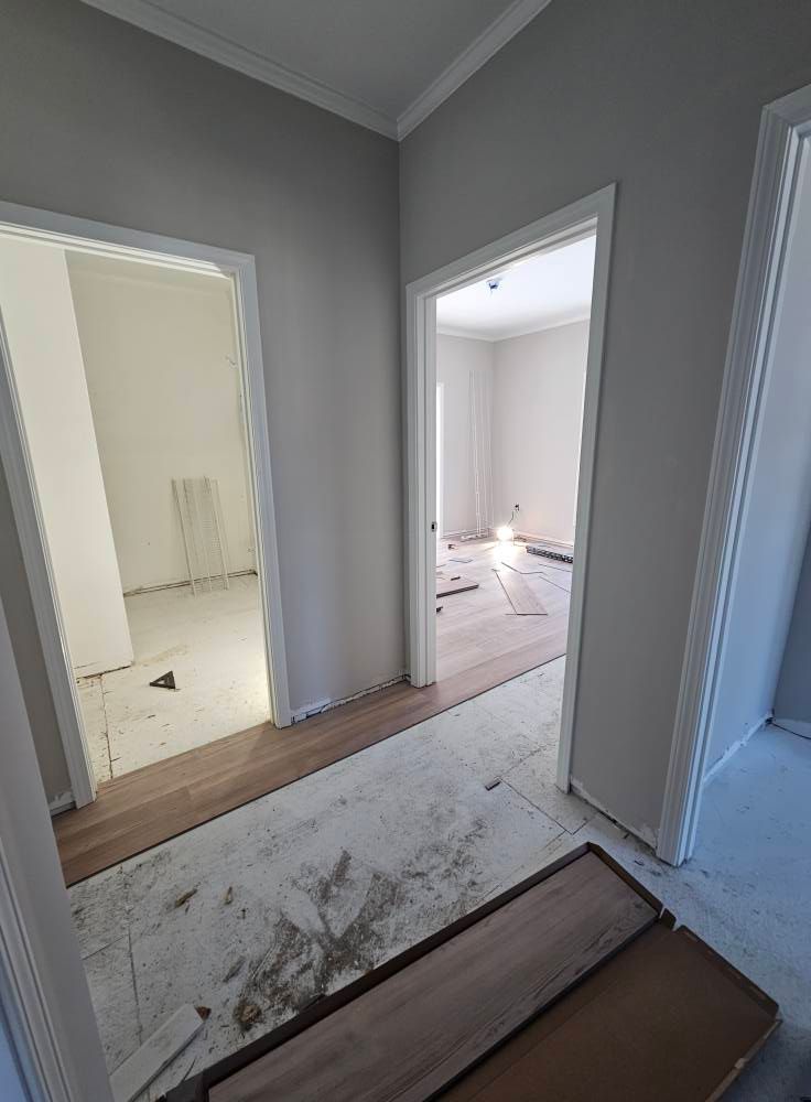 A hallway with a wooden floor in a house under construction.