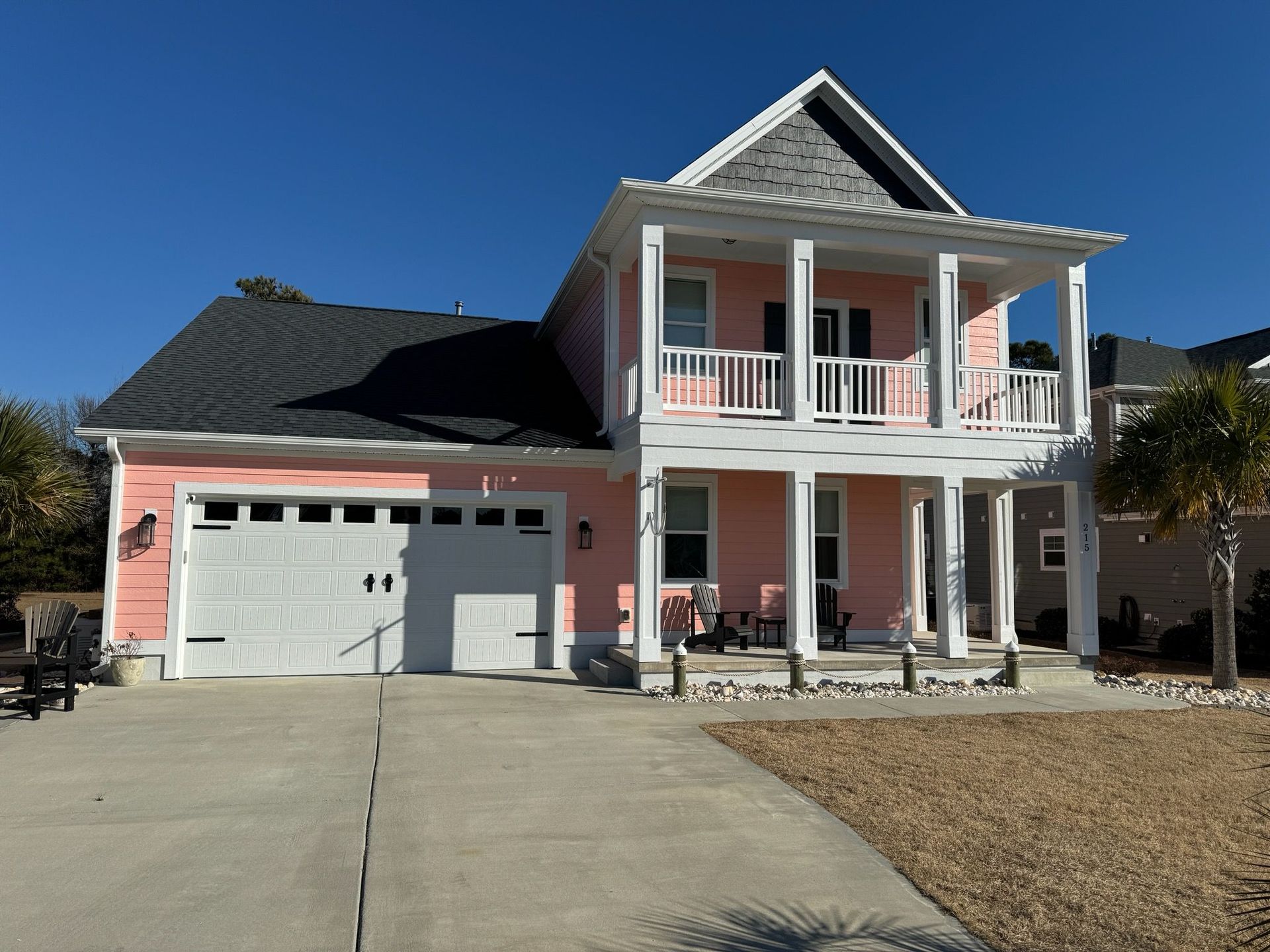A large pink house with a white garage door