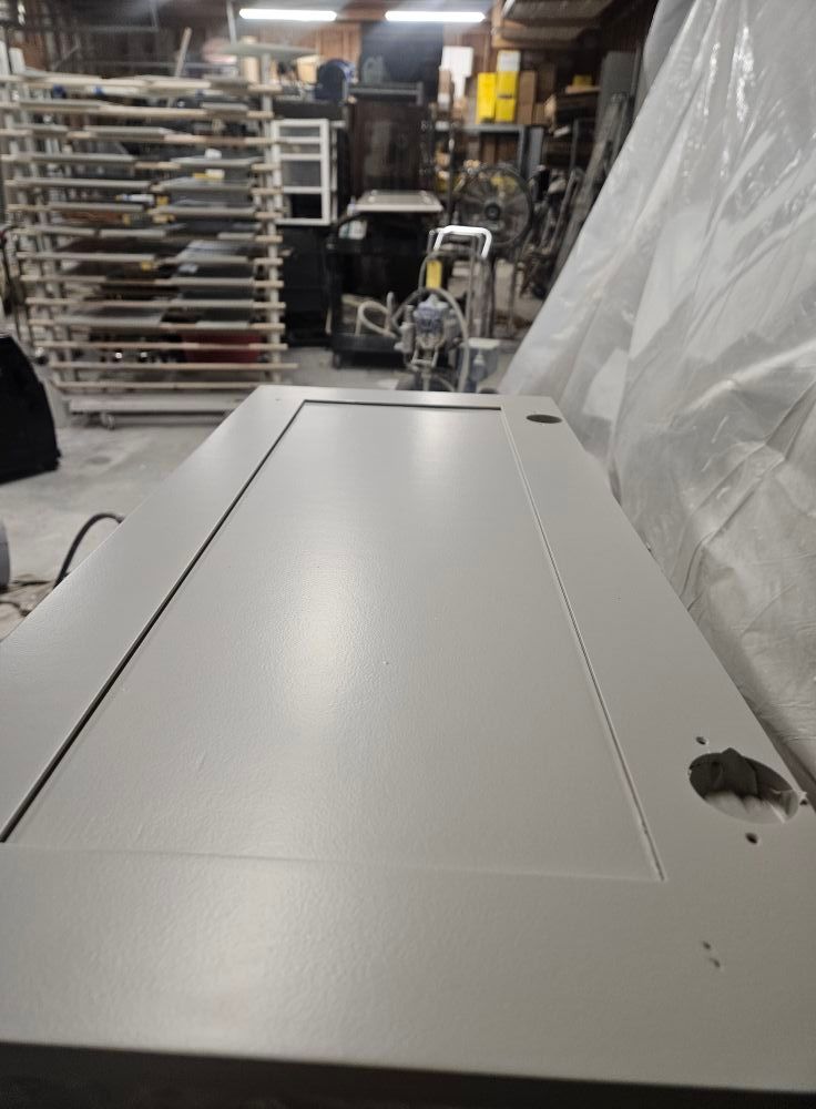 A white door is sitting on a table in a warehouse.