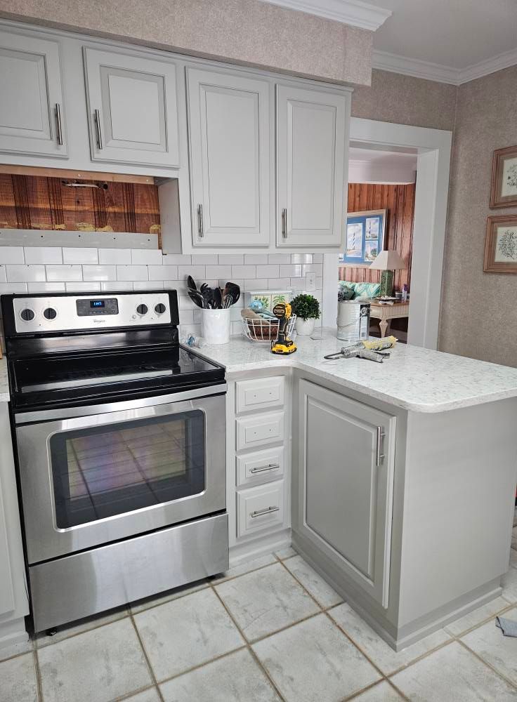 A kitchen with stainless steel appliances and white cabinets