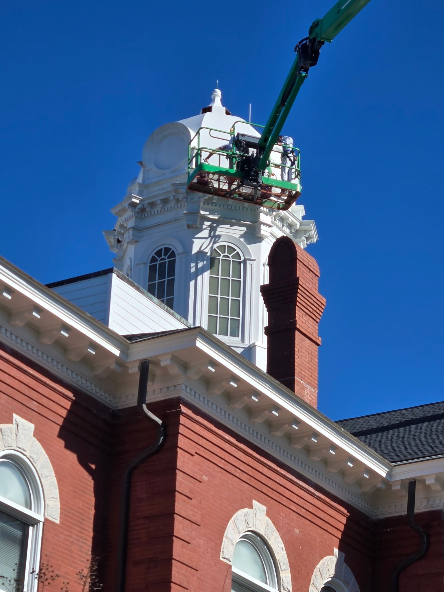 A brick building with a crane on top of it