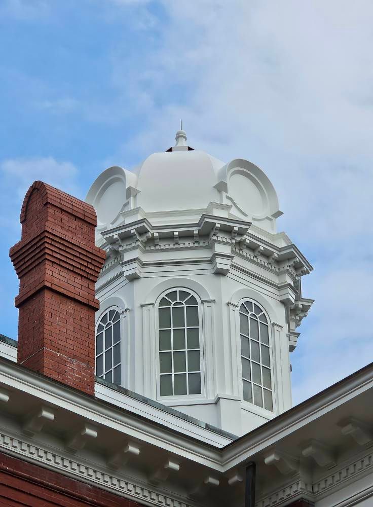 A building with a dome on top of it and a chimney on the side.
