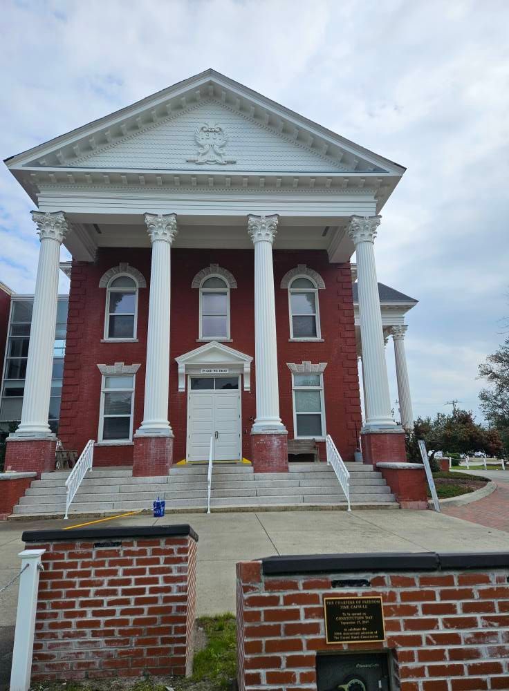 A red brick building with white columns and stairs