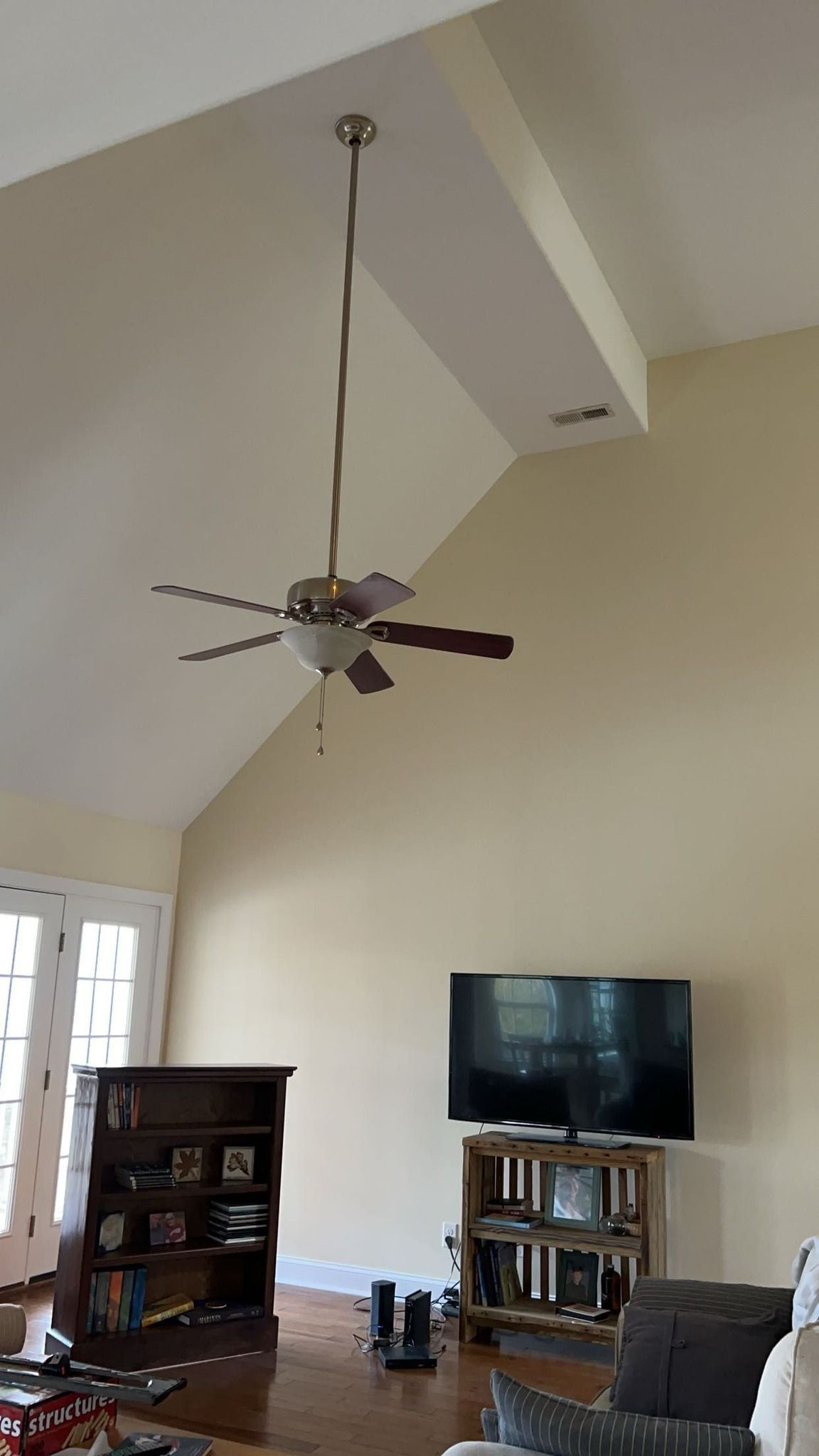 A living room with a ceiling fan and a flat screen tv.