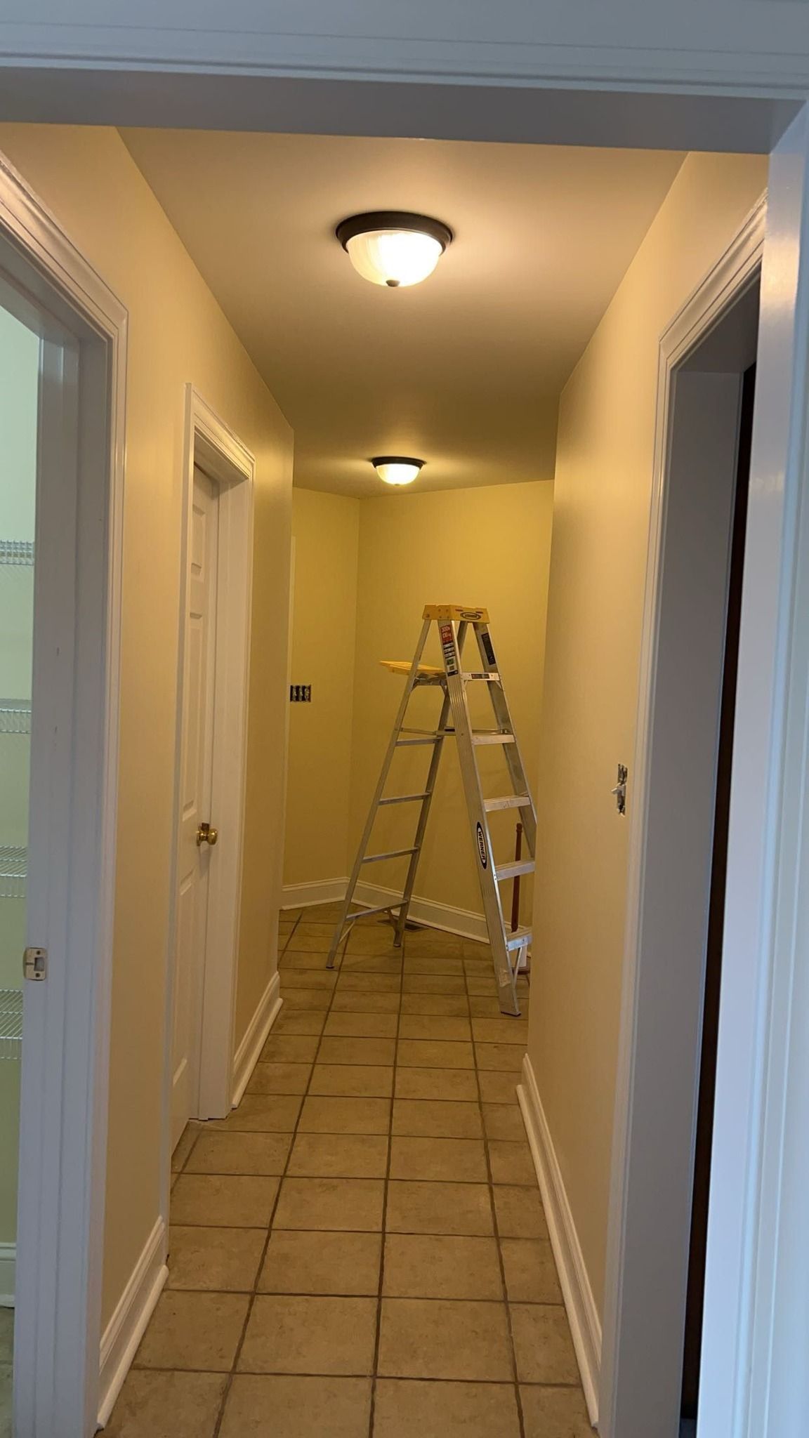 A hallway with a ladder in the middle of it.
