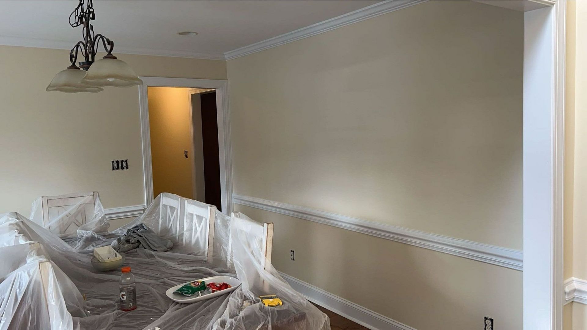 A dining room is being painted in a house.