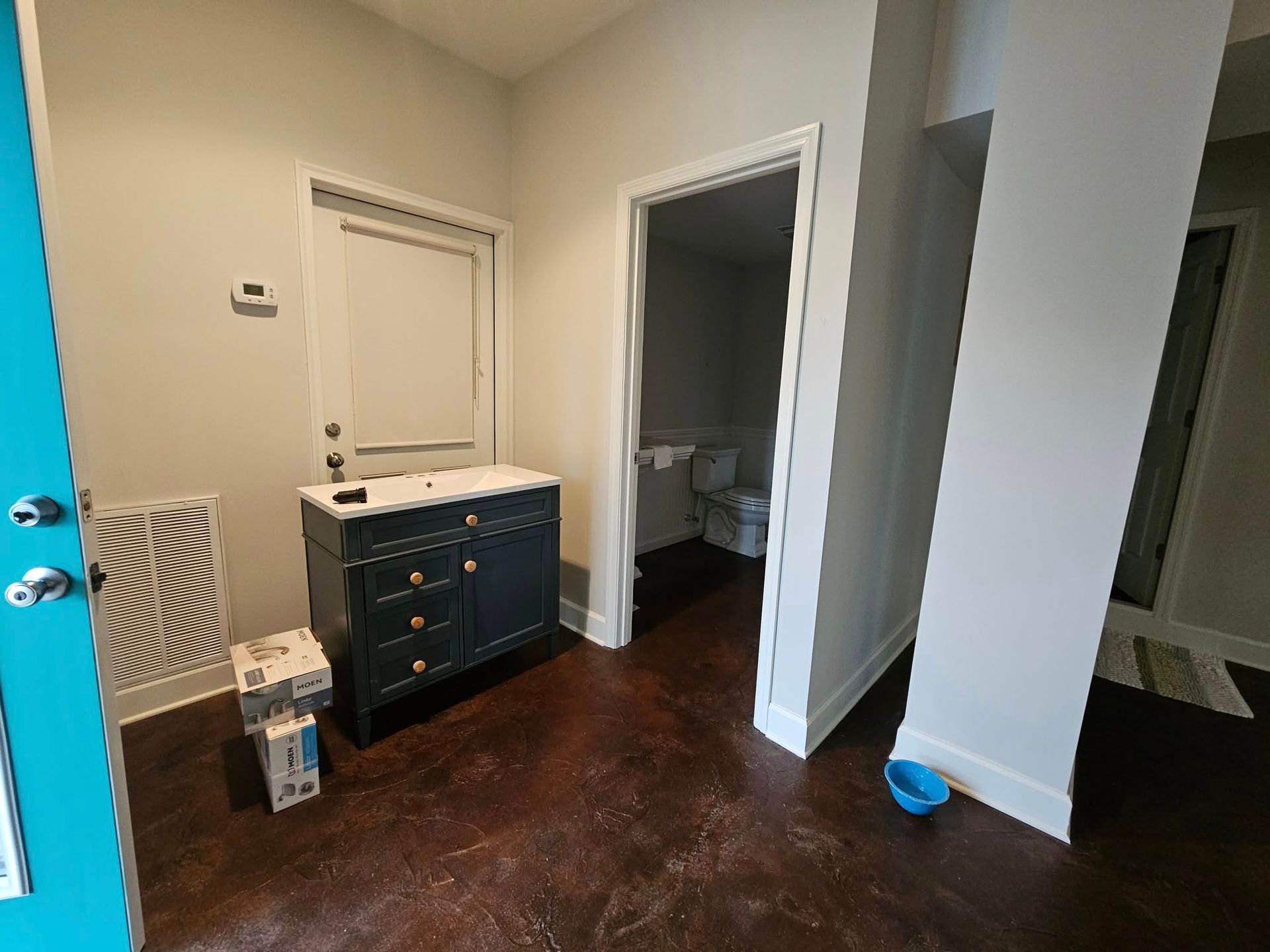 A bathroom with a sink , toilet and a blue door.