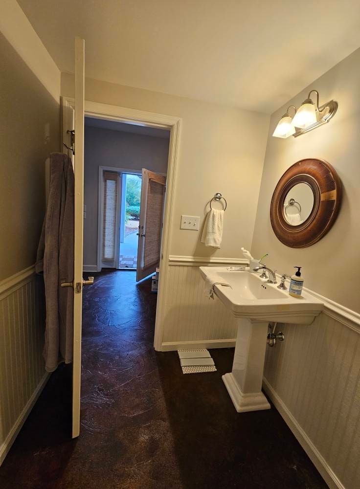 A bathroom with a pedestal sink and a mirror