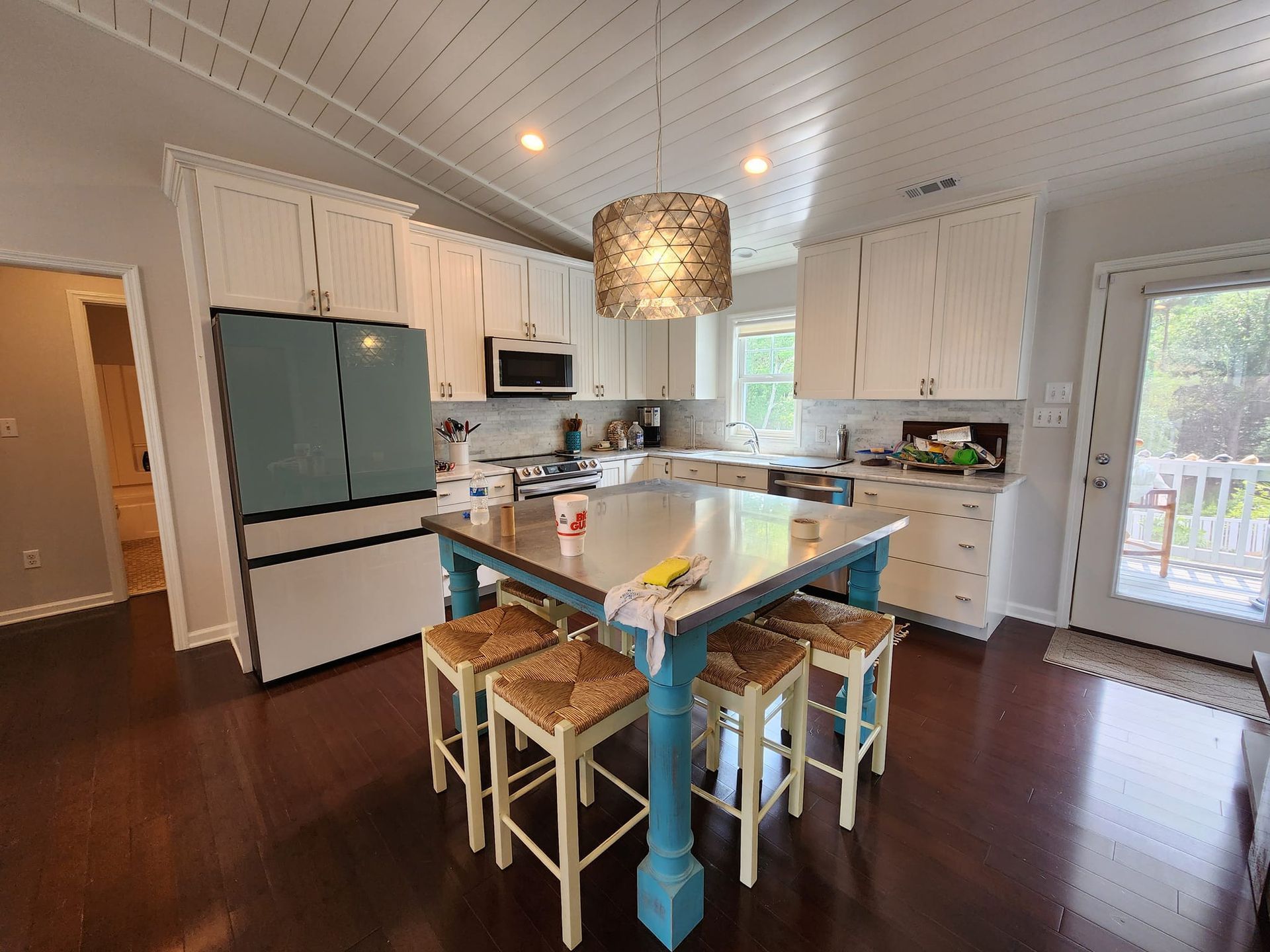 A kitchen with a table and stools in it