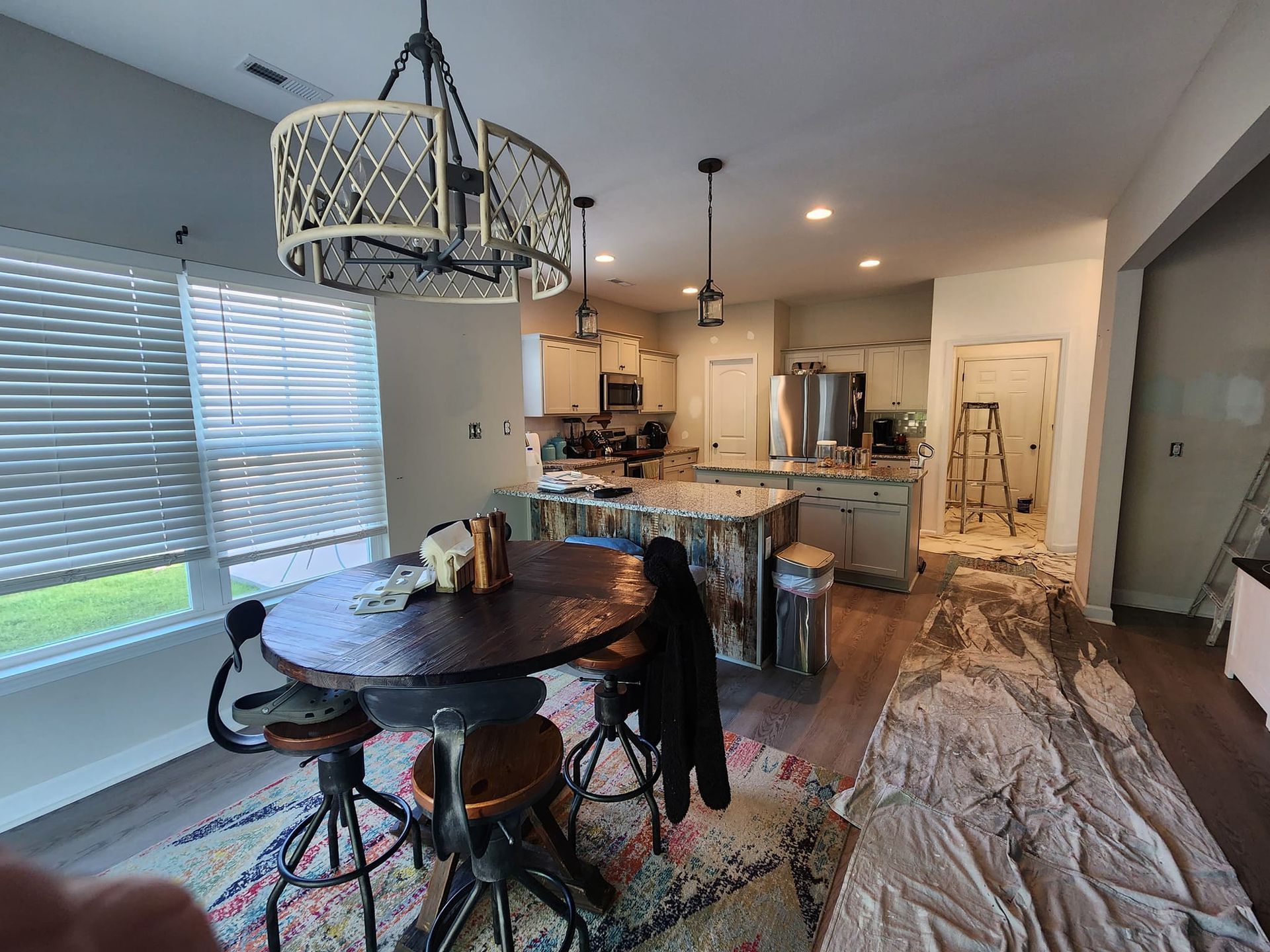 A kitchen with a table and chairs in it and a chandelier hanging from the ceiling.
