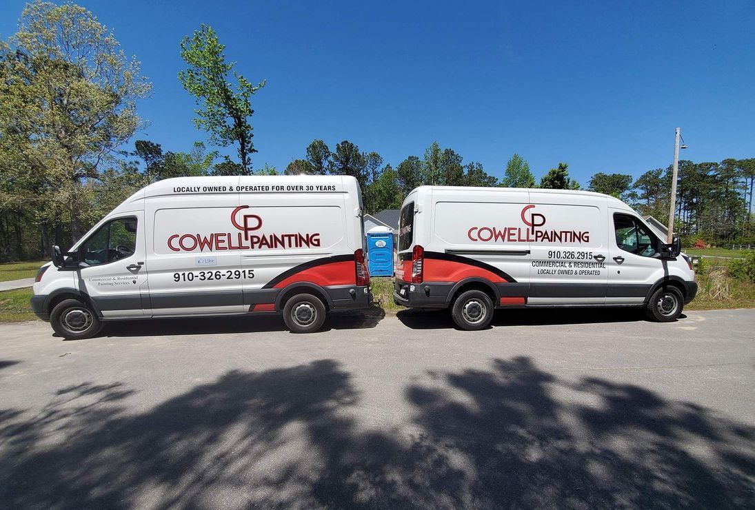 Two vans are parked next to each other on the side of the road.