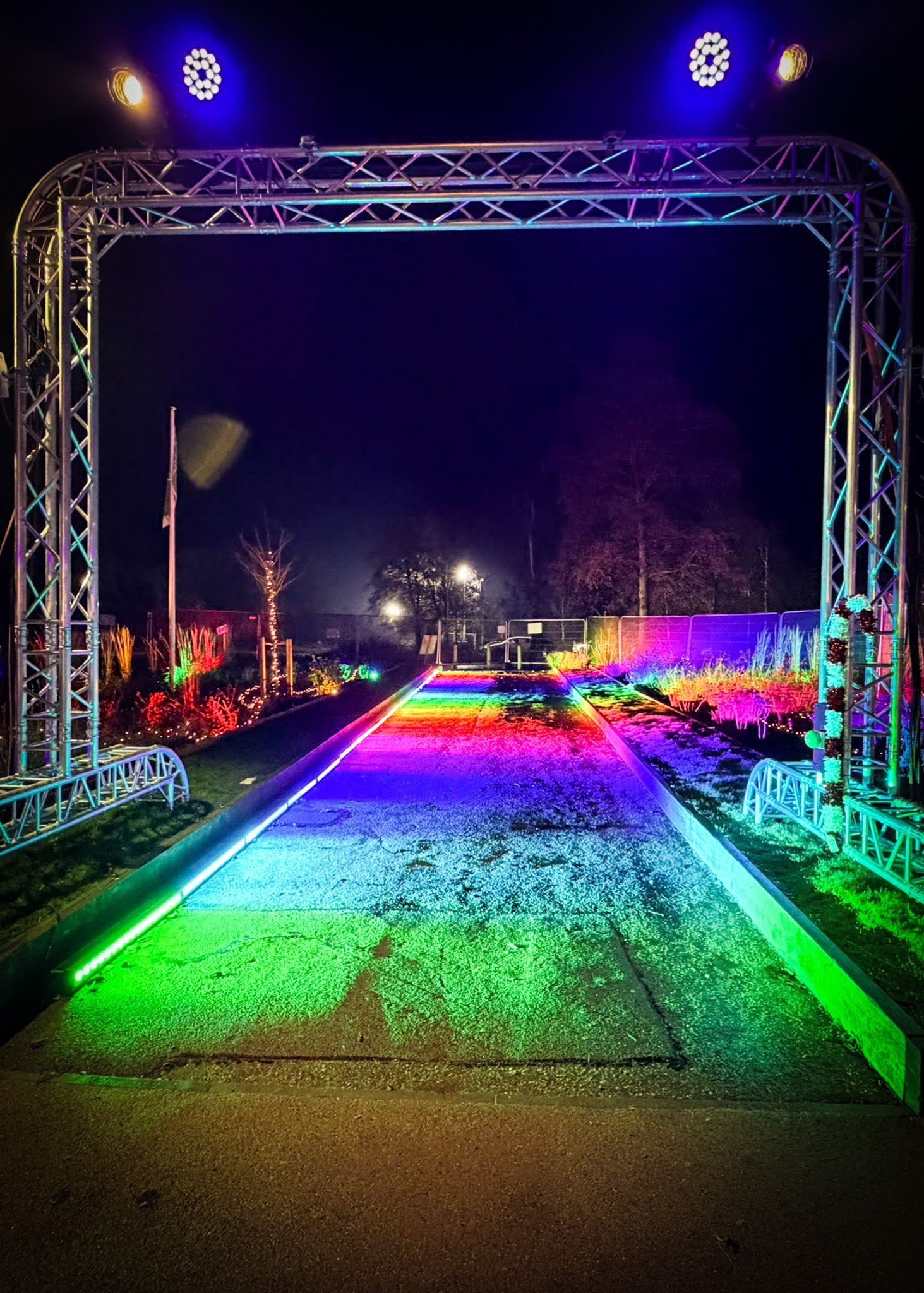 Rainbow-lit walkway entrance created with professional event lighting design.