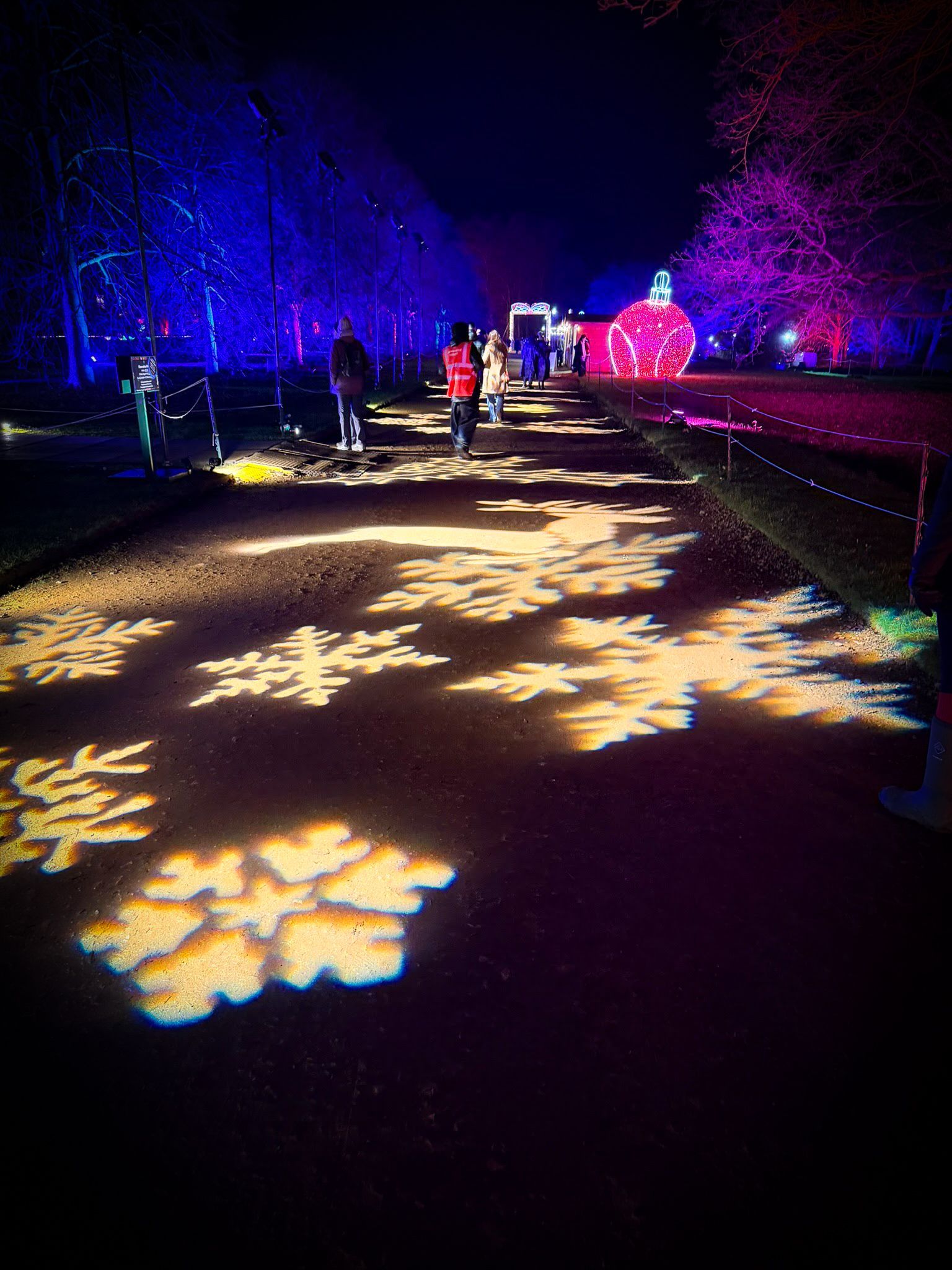 Projected festive images on walkway floor including snowflakes, snowmen, and text.