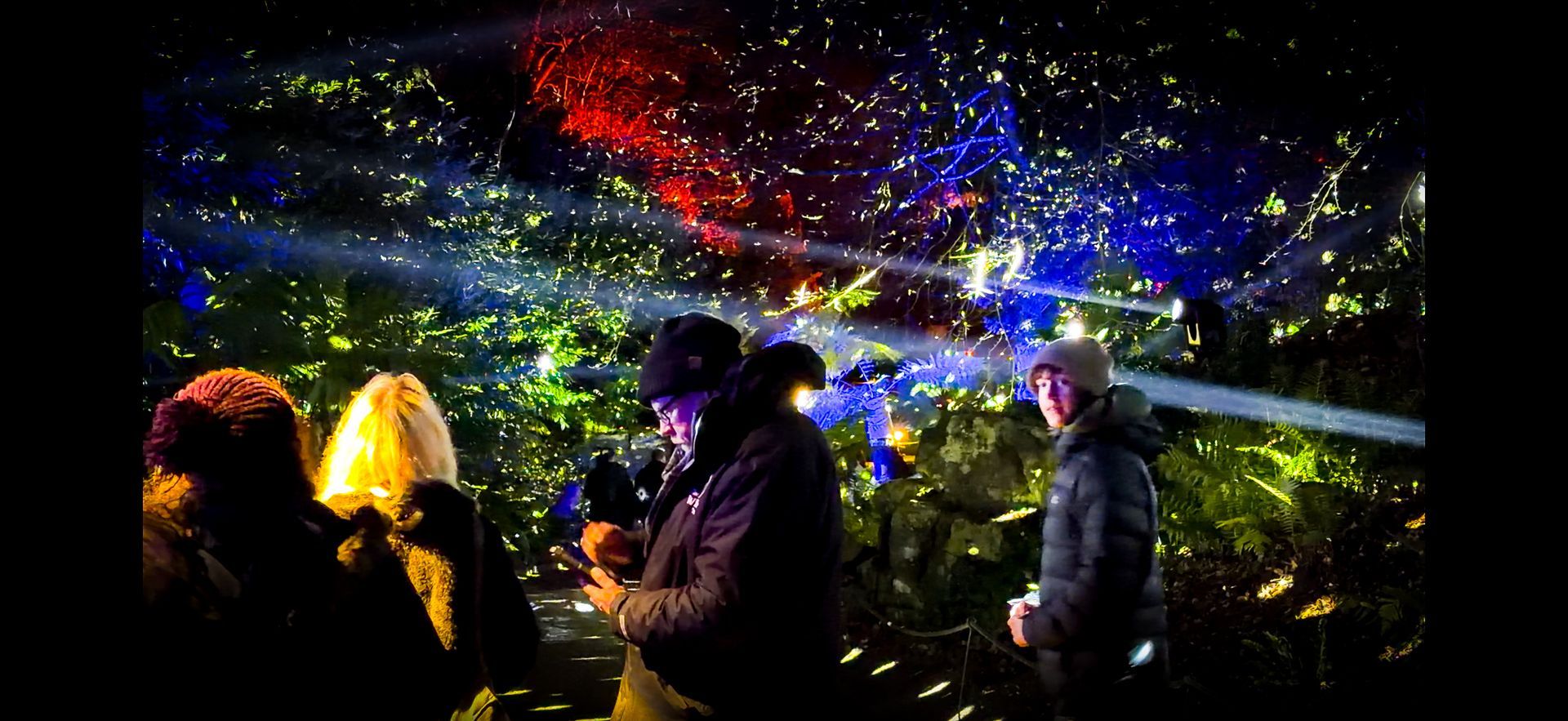 Mirror balls illuminated by spotlights creating immersive light trail effect.
