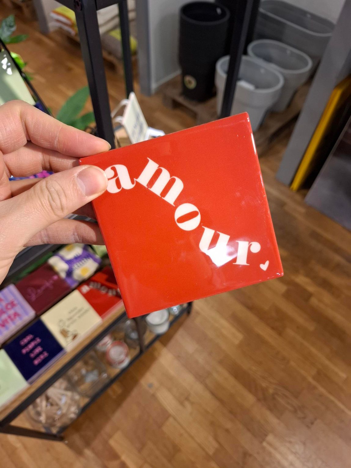 Hand die een rood vierkant kaartje met de witte tekst