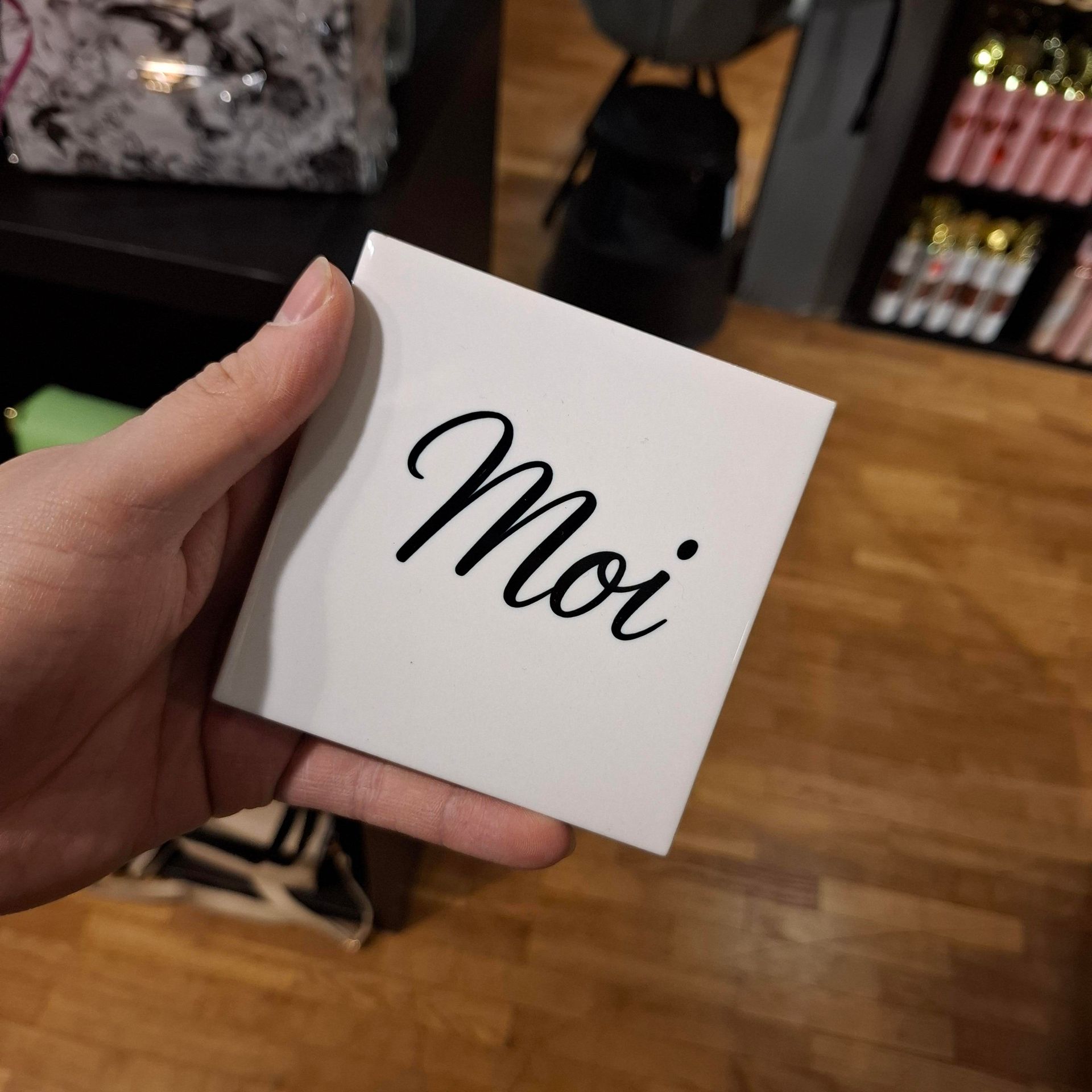 Een hand houdt een klein wit kaartje vast met het woord