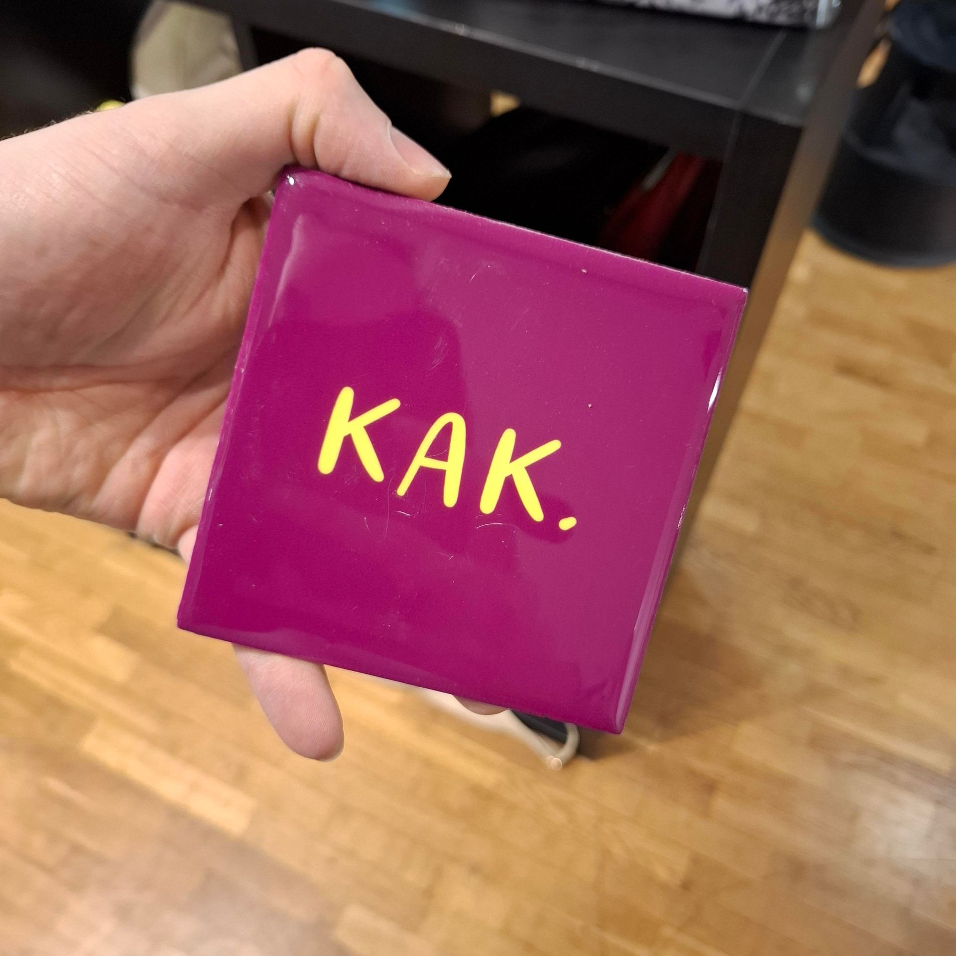 Hand die een paarse vierkante doos met gele