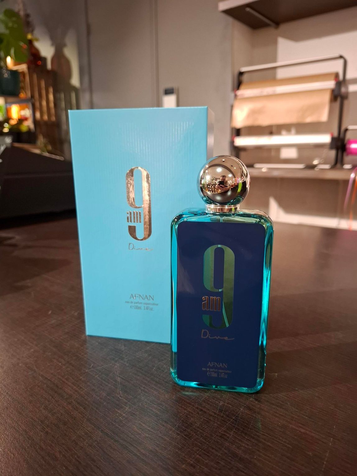Een blauw parfumflesje en het bijbehorende doosje met het opschrift