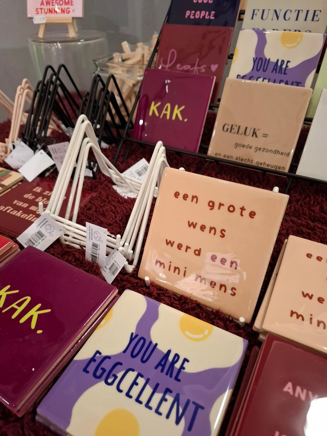 Een display met kleurrijke, inspirerende kaarten met Nederlandse woorden, waaronder
