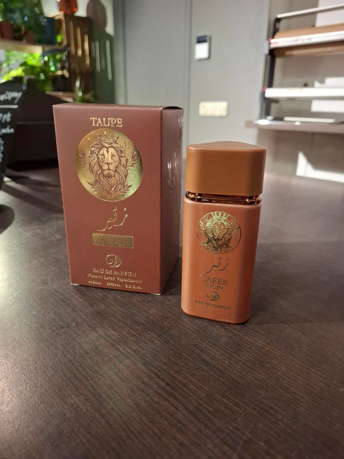 Bruine cosmeticafles naast een bijpassend doosje op een donkere tafel in een zonnige kamer.