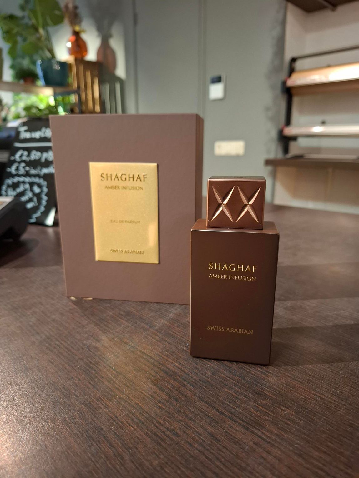 Bruine SHAGHAF parfumfles en doos op een houten tafel binnen.