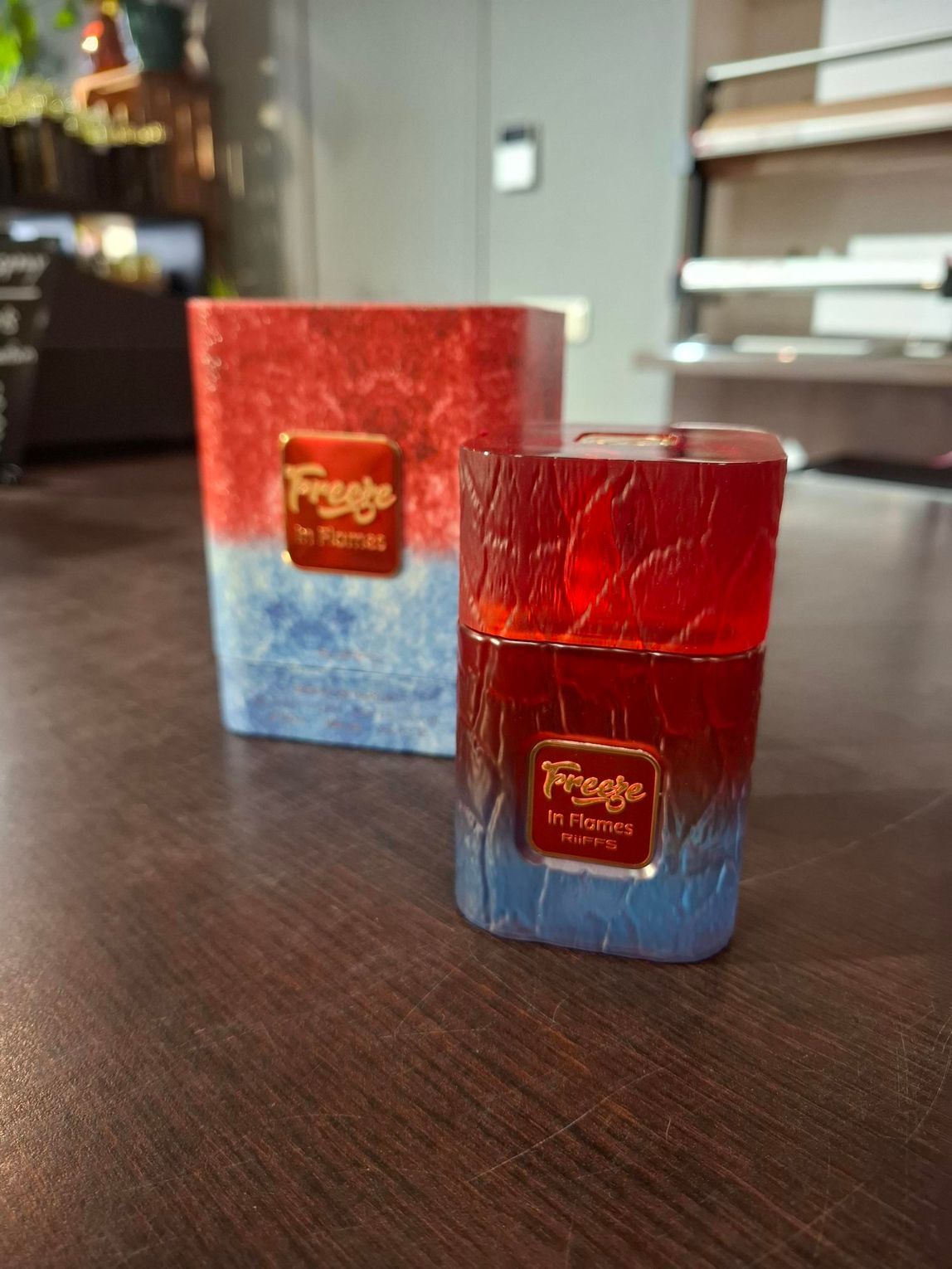 Twee rood-blauwe glazen kaarsenstandaards op een houten tafel binnen.