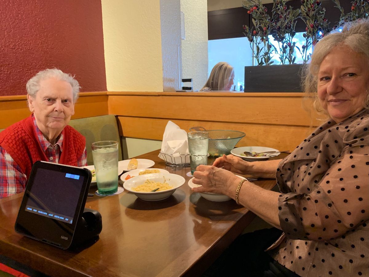 an elderly woman and a woman are sitting at a table in a restaurant