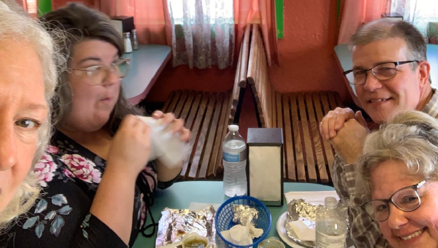 a group of people are sitting at a table in a restaurant .